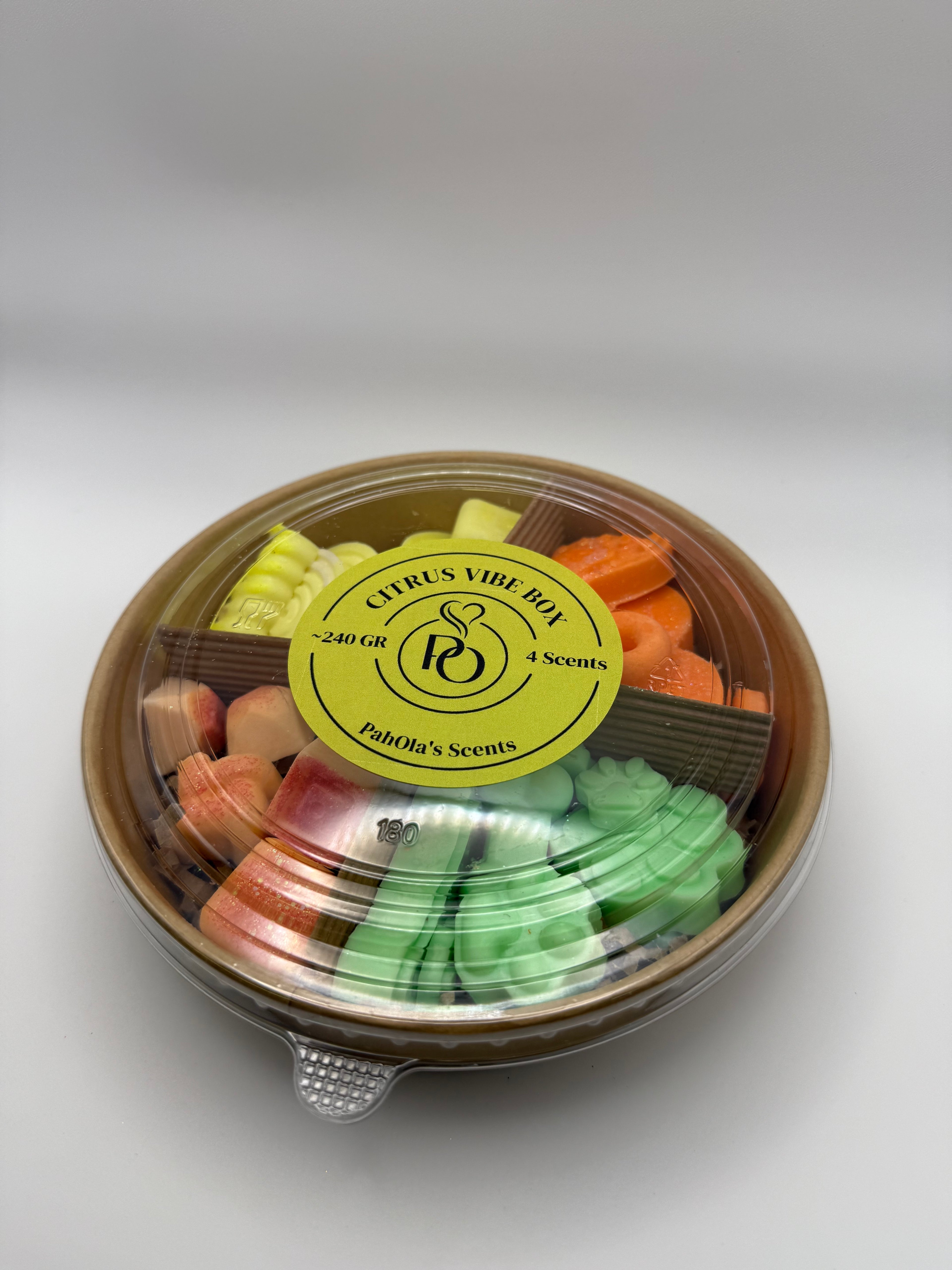 Round container of colorful wax melts on a white background
