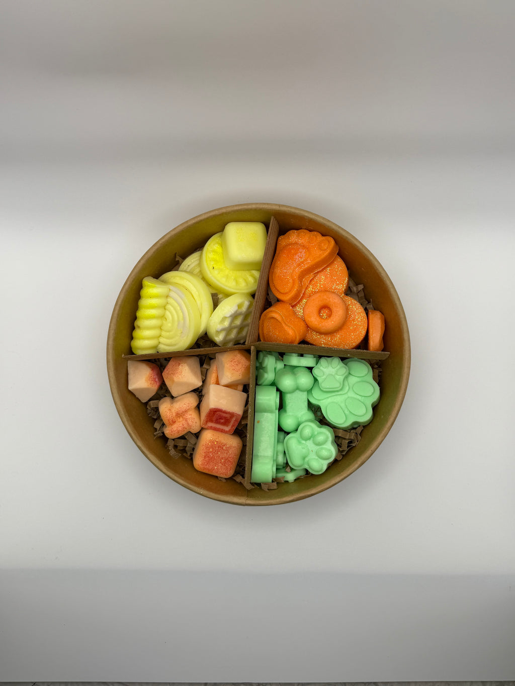 Round container of colorful wax melts on a white background
