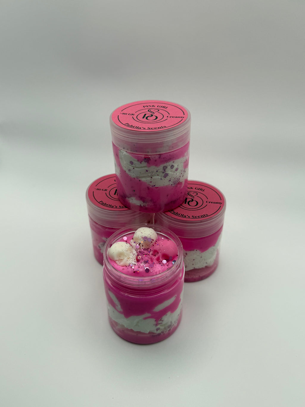 Three pink and white containers with decorative elements on a light gray background