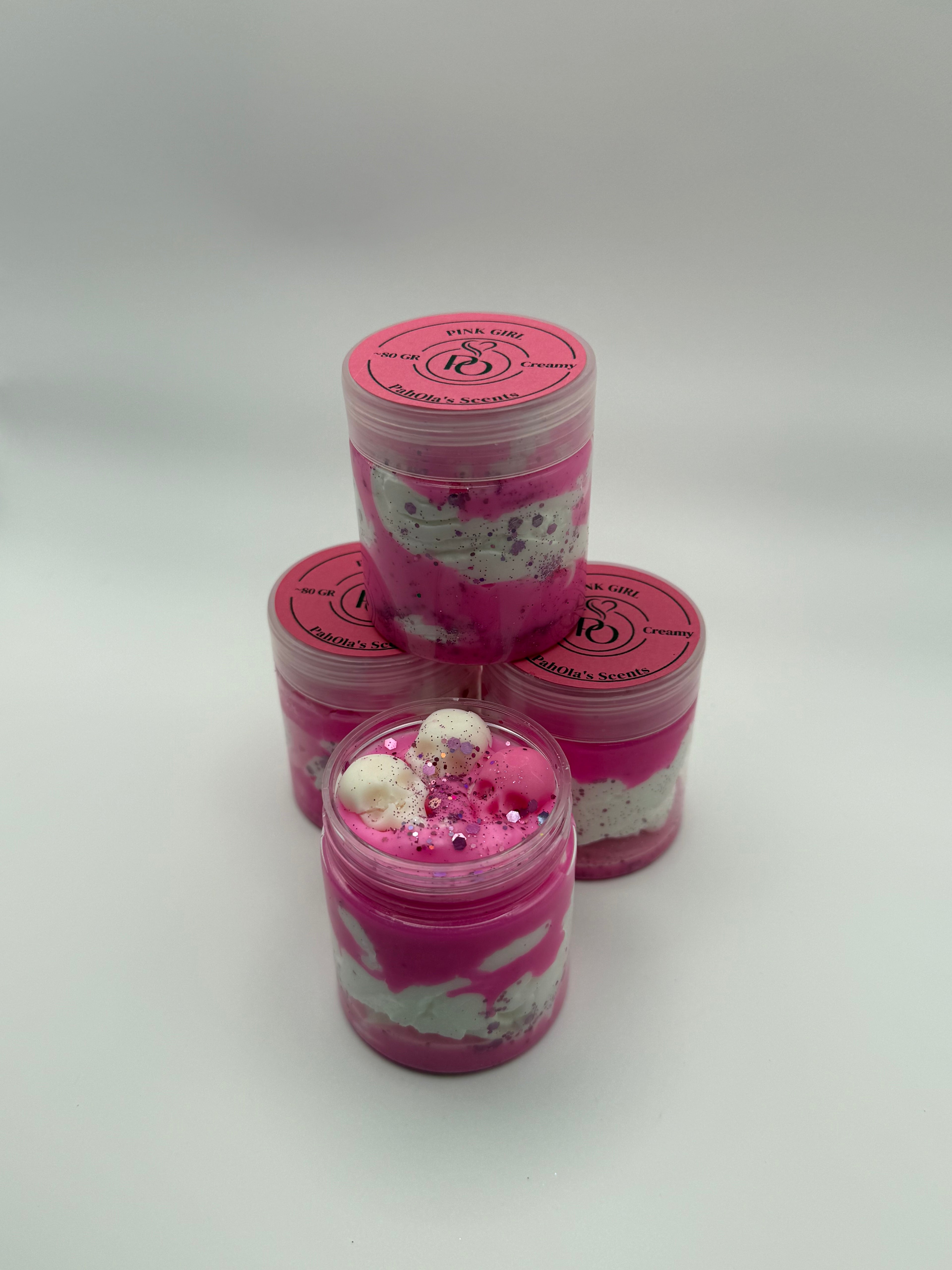 Three pink and white containers with decorative elements on a light gray background