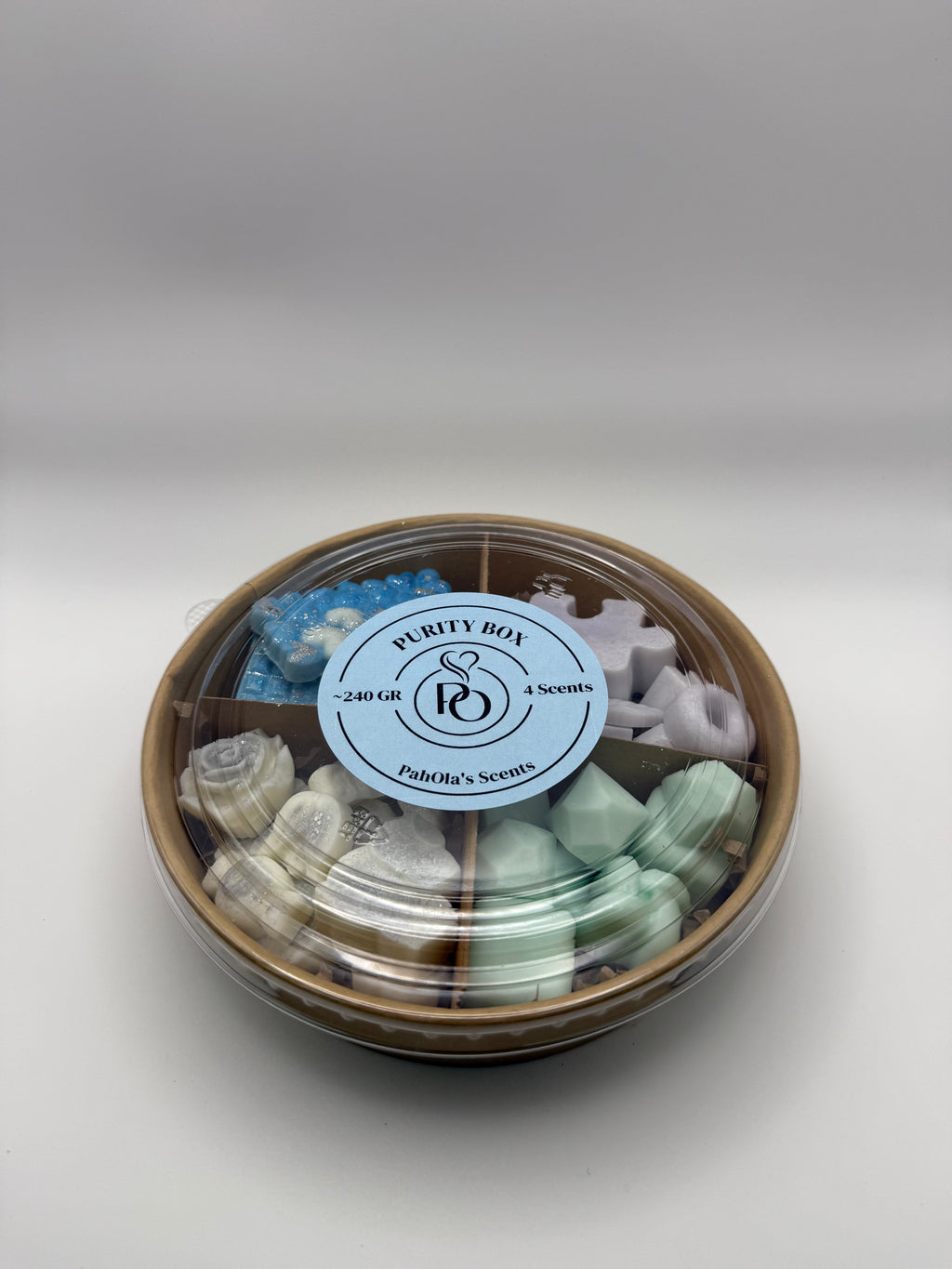 Round container of colorful wax melts on a white background