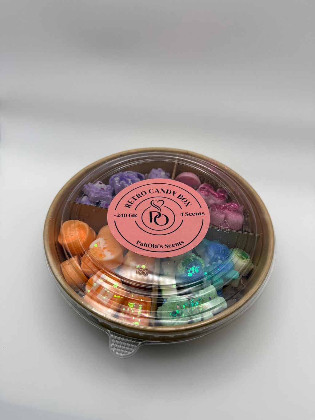 Round container of colorful wax melts on a white background