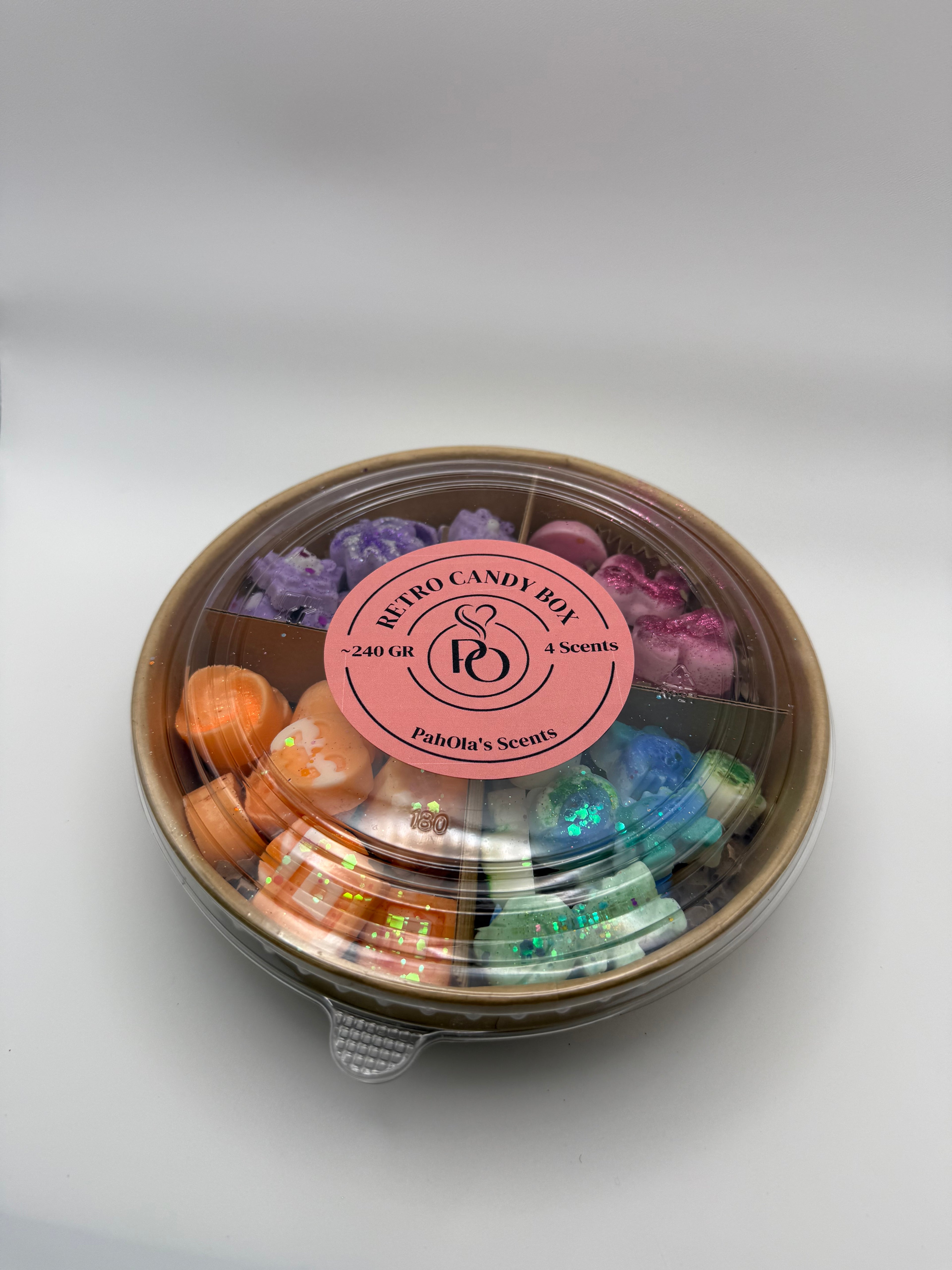 Round container of colorful wax melts on a white background