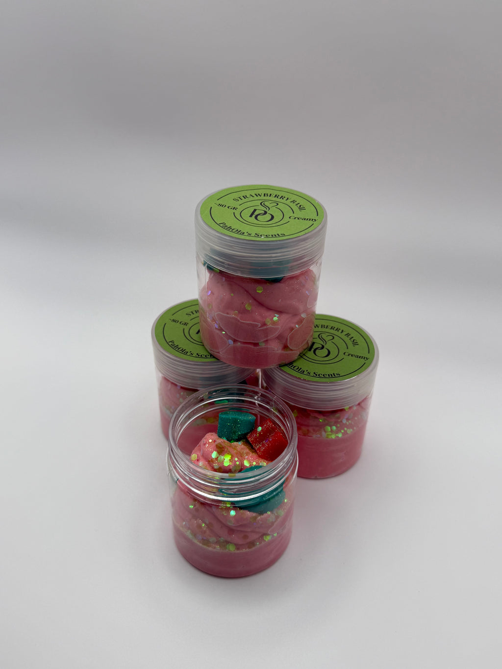 Set of pink containers with green labels on a white background