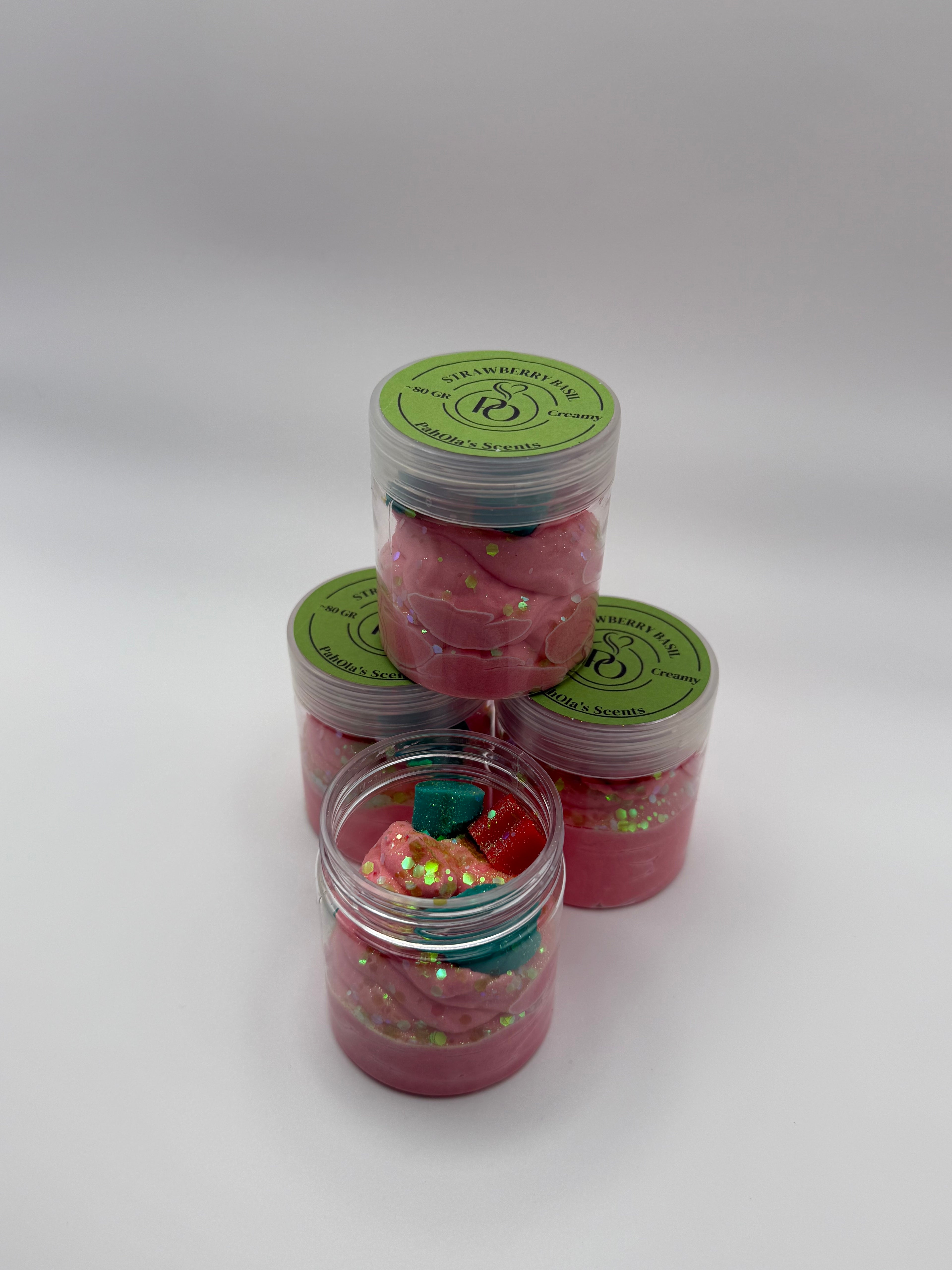 Set of pink containers with green labels on a white background