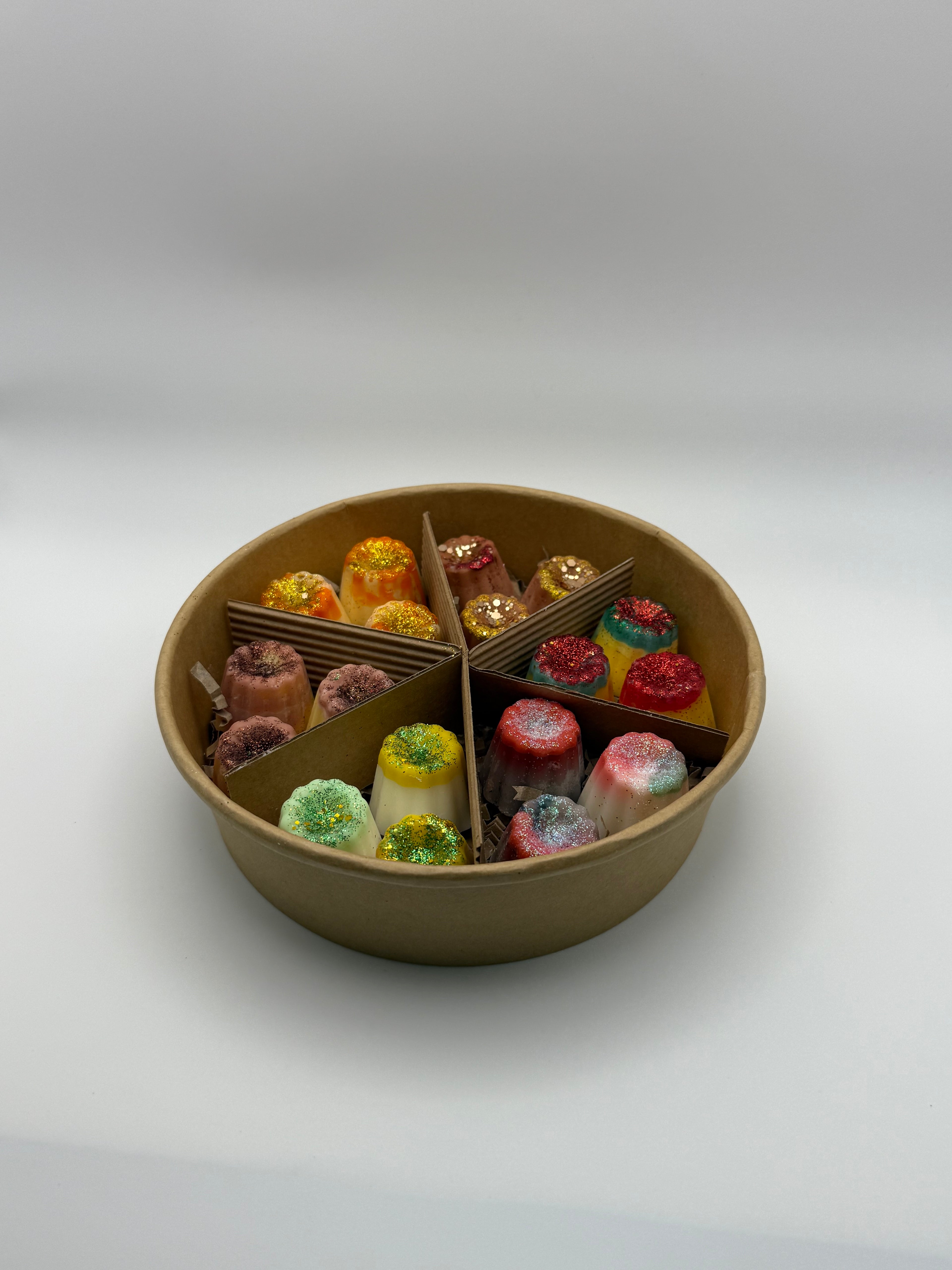 Round container of colorful wax melts on a white background