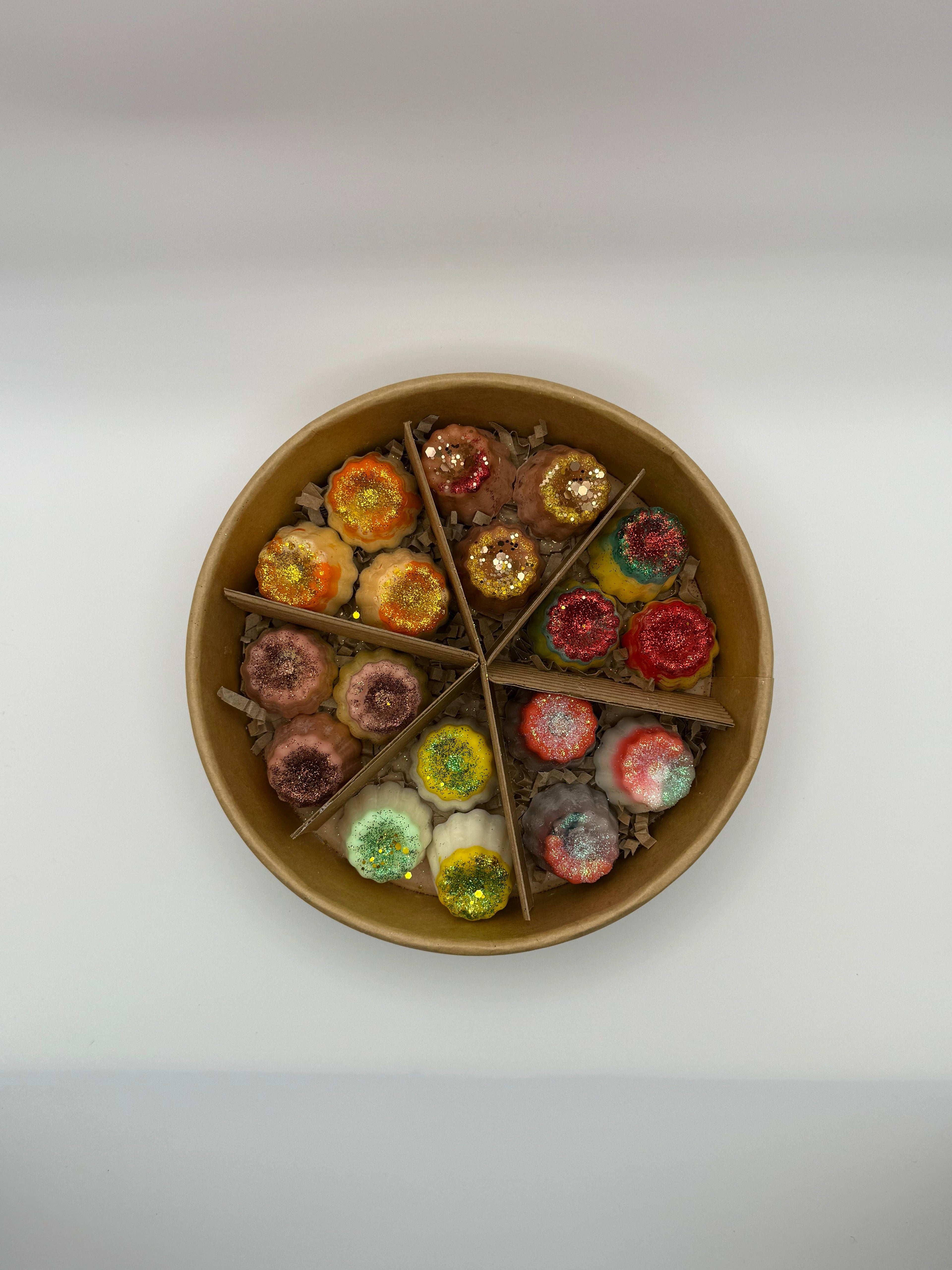 Round container of colorful wax melts on a white background