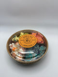 Round container of colorful wax melts on a white background