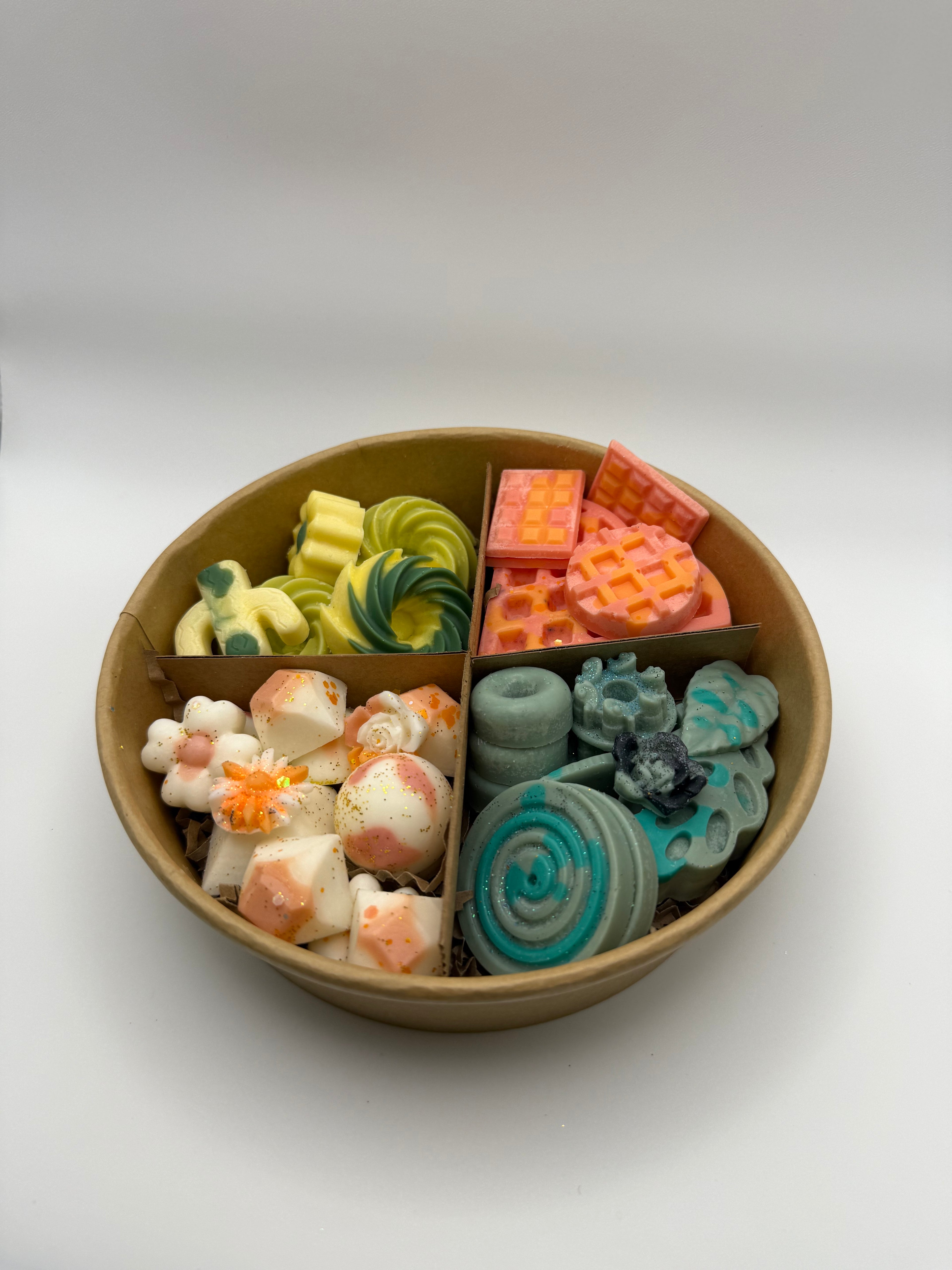 Round container of colorful wax melts on a white background